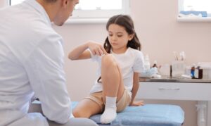 Παιδί δείχνει στον ορθοπεδικό το γόνατο που πονάει